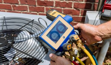 Technician performing an AC Service at a home in Quogue, NY